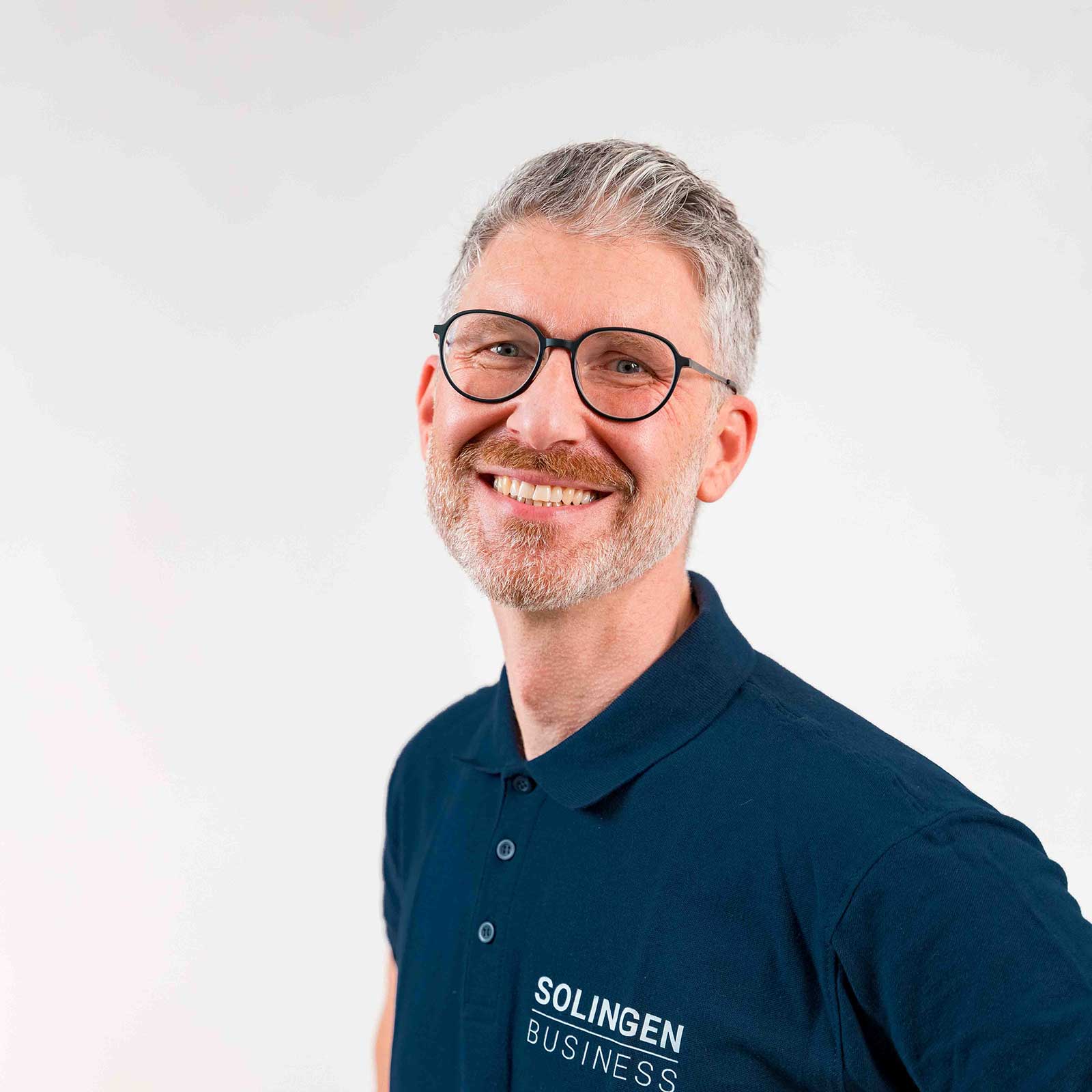Porträt von Elmar Jünemann Teammitglied von Solingen.Business, in blauem Poloshirt vor hellem Hintergrund