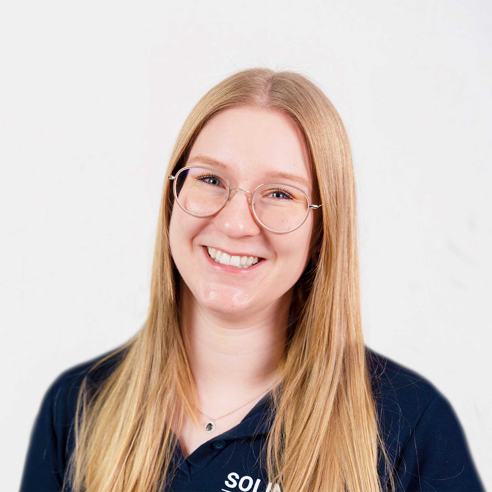Porträt von Franziska Hahn, Teammitglied von Solingen.Business, in blauem Poloshirt vor hellem Hintergrund